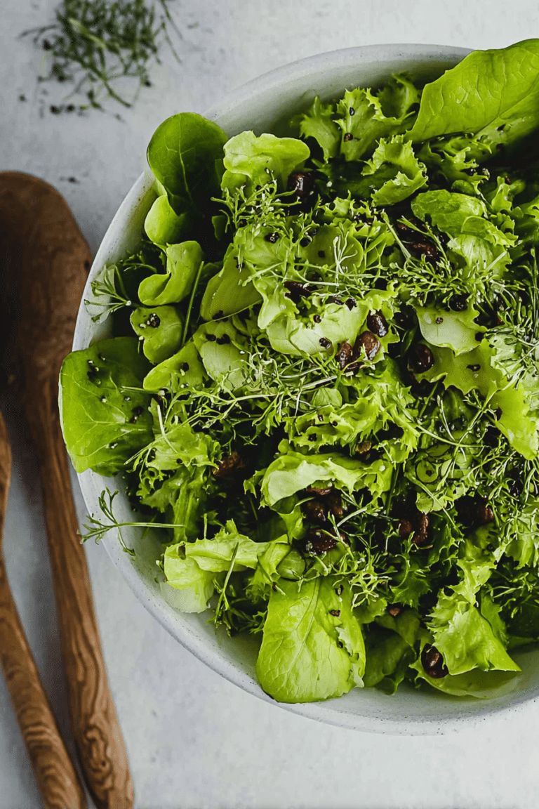 Ein einfacher grüner Salat mit gemischten Salatblättern, gerösteten Haselnüssen und Balsamico-Dressing in einer großen Schüssel.