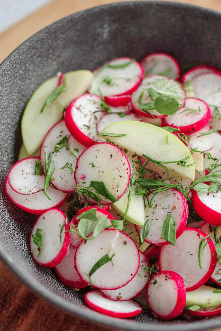 Frischer Radieschen-Salat mit Äpfeln, Dill und Frühlingszwiebeln in einer Schüssel, perfekt für ein Sommerpicknick.