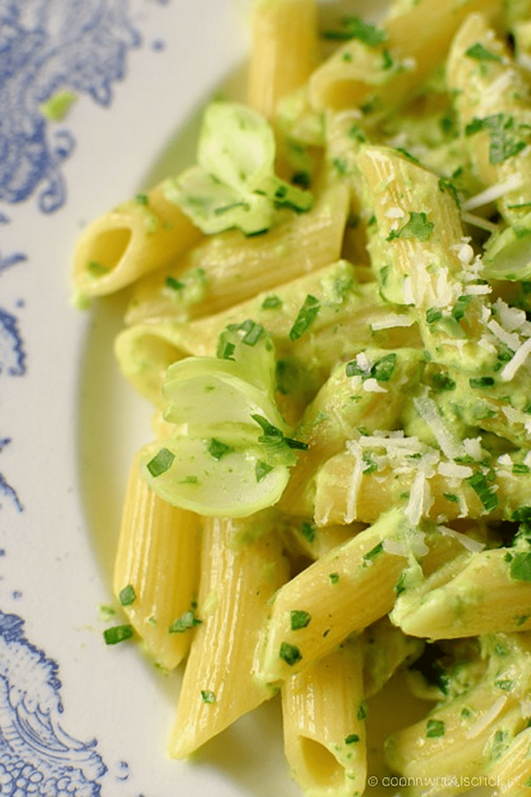 Dampfende Pasta mit Bärlauch-Parmesan-Sauce in einer Schüssel, garniert mit frischem Bärlauch und Parmesan.