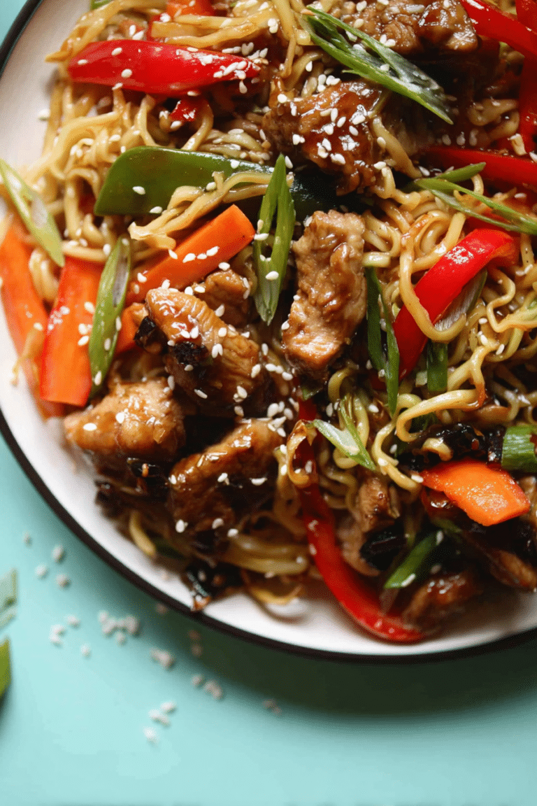Asiatische Hähnchen-Gemüse-Pfanne mit frischem Gemüse und Mie-Nudeln, serviert auf einem weißen Teller.