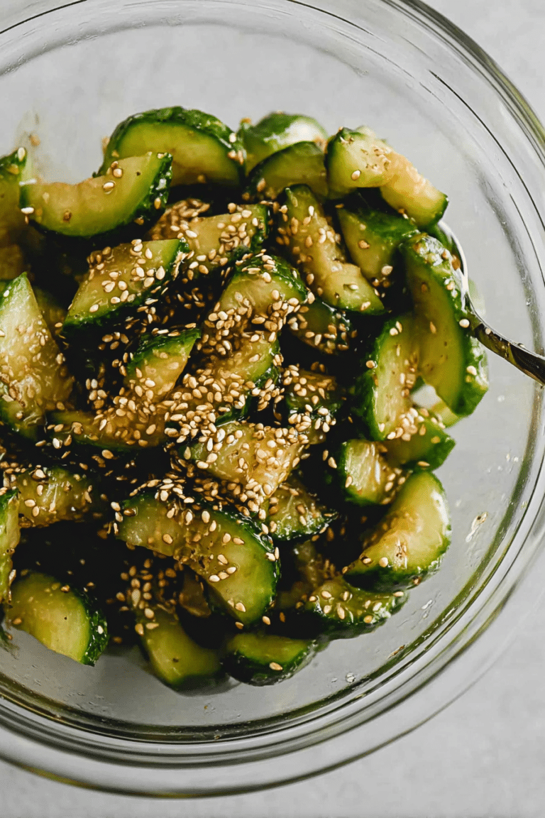 Asiatischer Gurkensalat mit Sesam auf einem Teller mit frischen Zutaten.