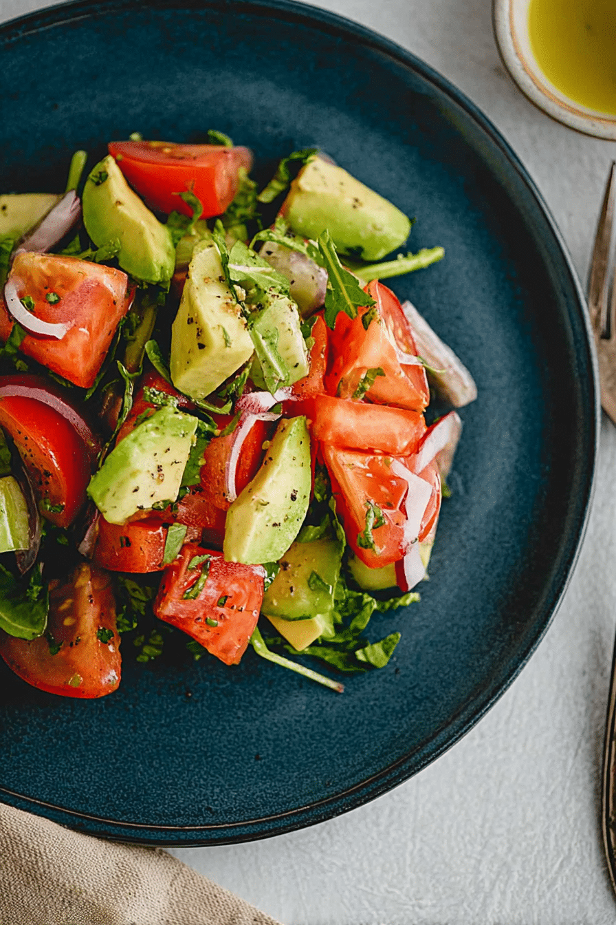 Frisch zubereiteter Avocado Tomaten Salat mit Koriander und Zwiebeln in einer Schüssel.