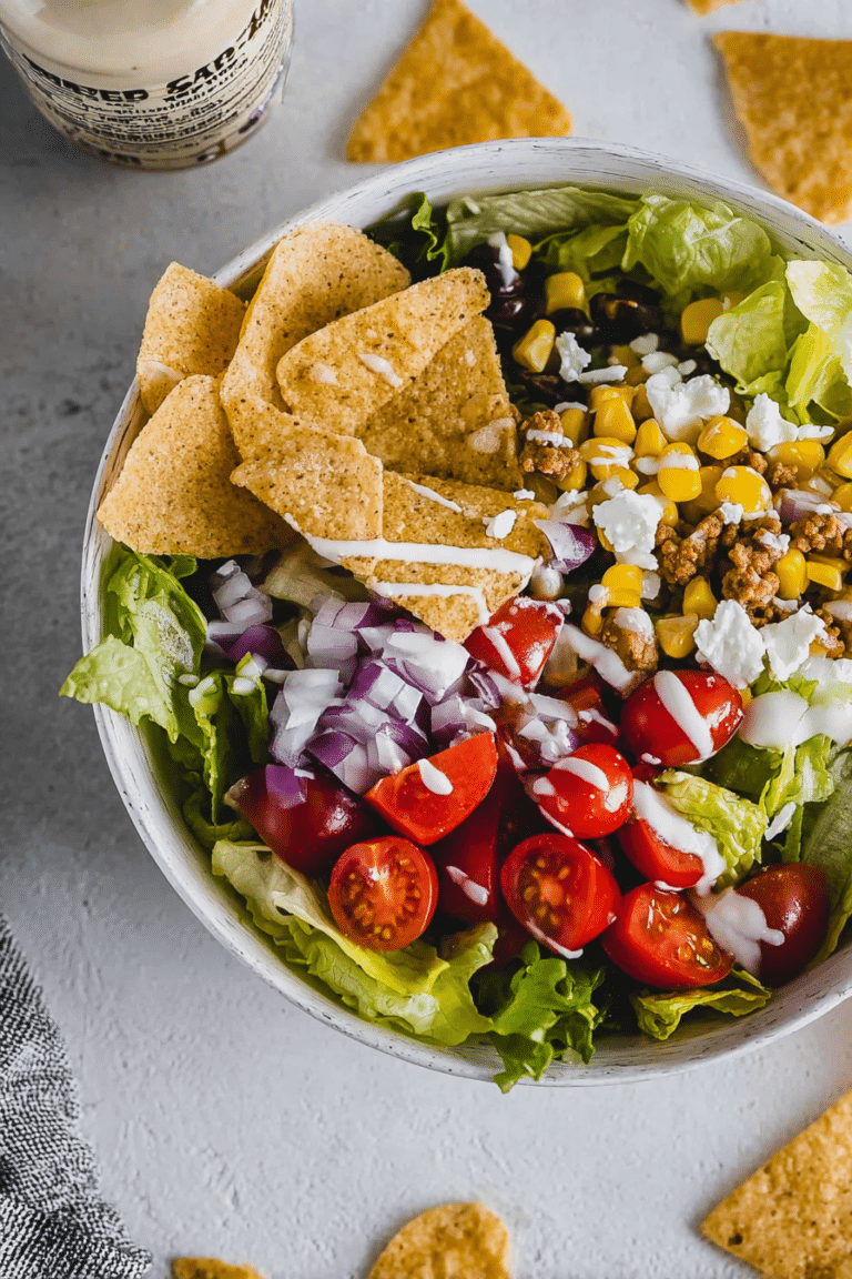 Bunter vegetarischer Taco Salat mit frischem Gemüse und Tortilla Chips in einer großen Schüssel.
