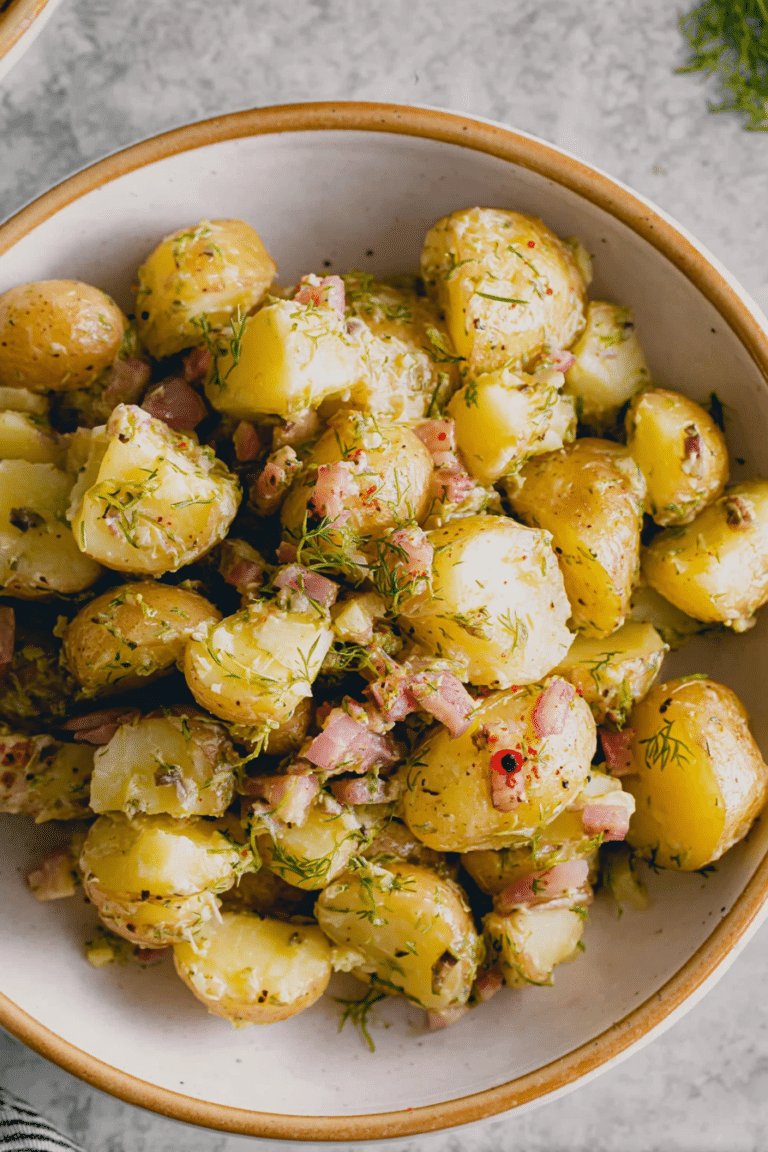 Frischer Kartoffelsalat mit Essig und Öl, garniert mit Dill und Schalotten