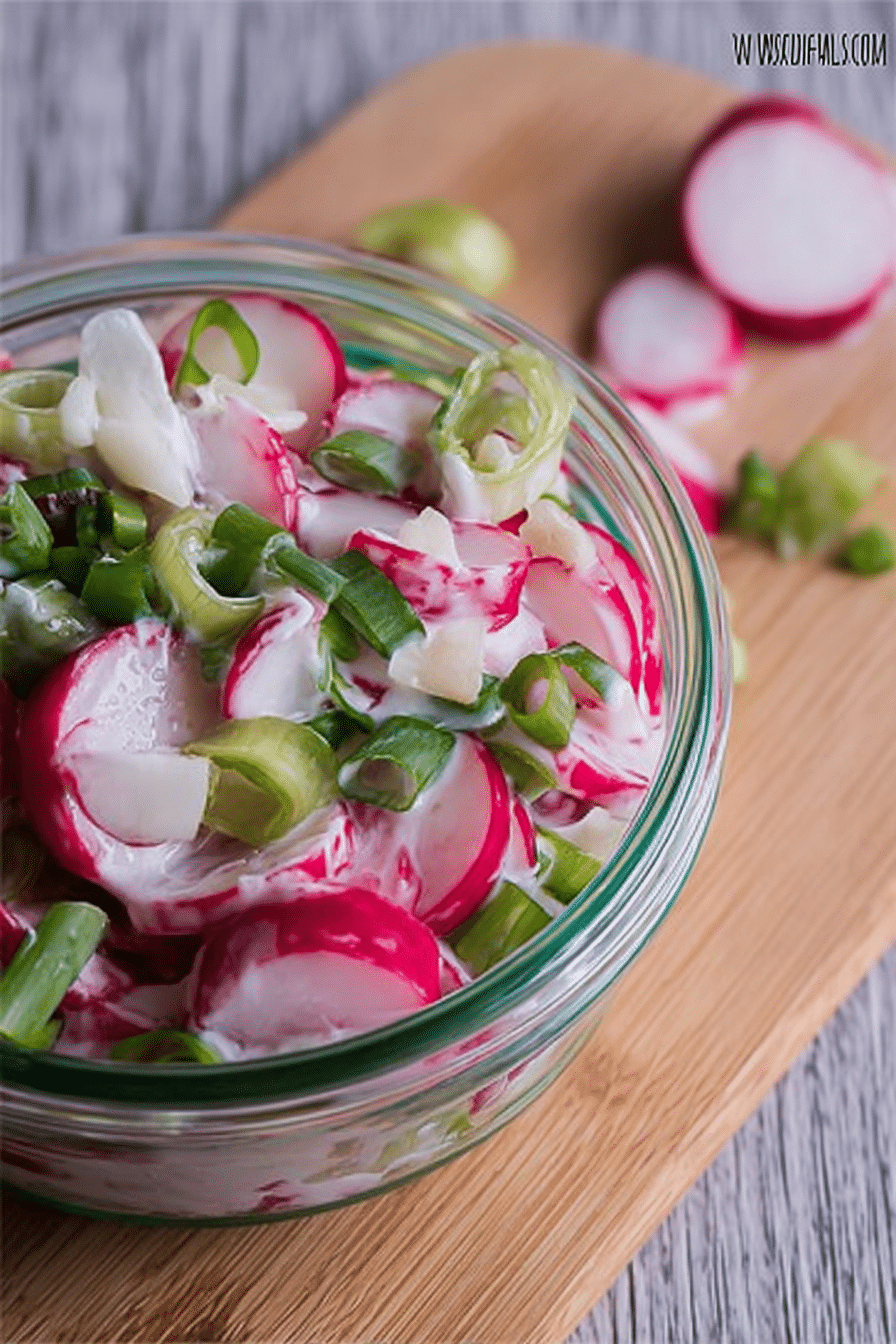 Erfrischender Radieschensalat mit Sahne und Frühlingszwiebeln in einer großen Schüssel.