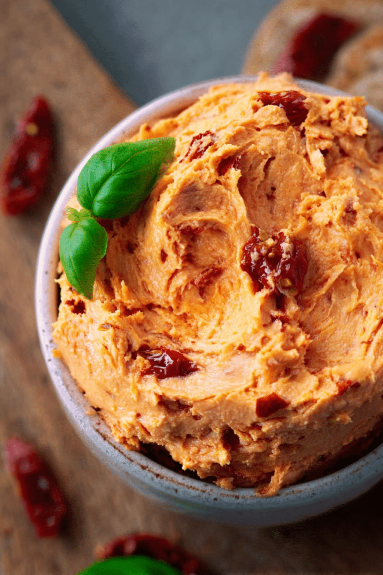 Frisch zubereitete Tomatenbutter mit getrockneten Tomaten und Kräutern in einer Schüssel.