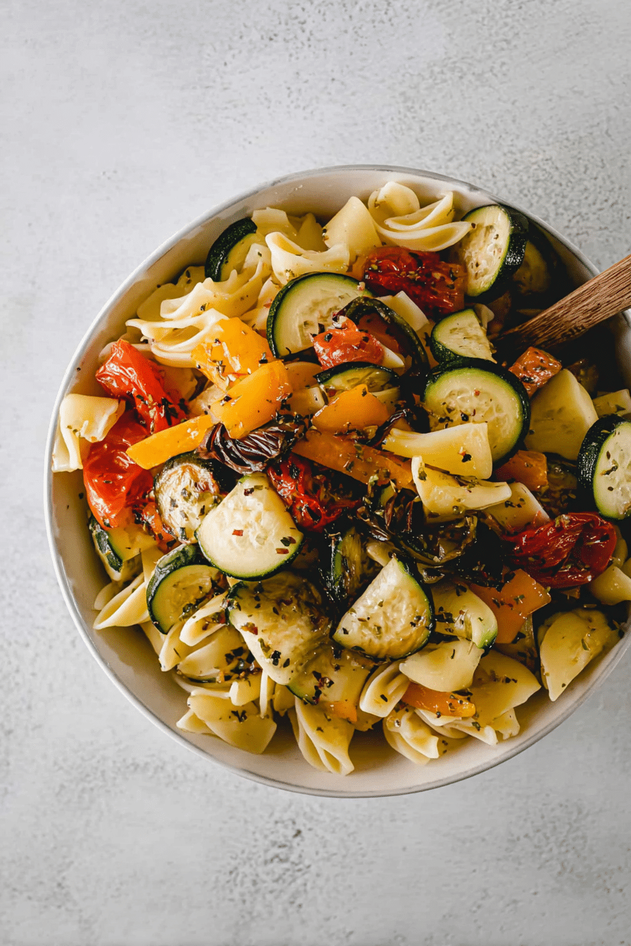 Bunter vegetarischer Nudelsalat mit geröstetem Gemüse und frischem Basilikum.