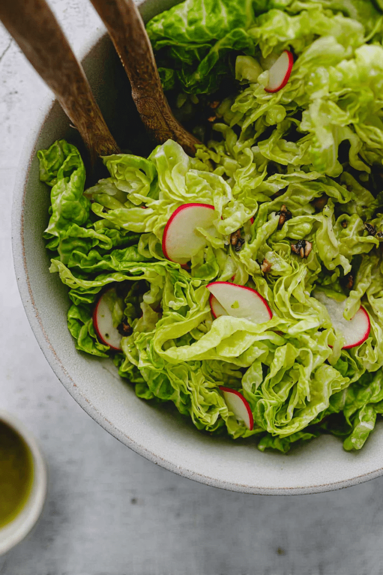 Zuckerhut Salat mit Apfel, Radieschen und Vinaigrette Dressing in einer eleganten Schüssel serviert.
