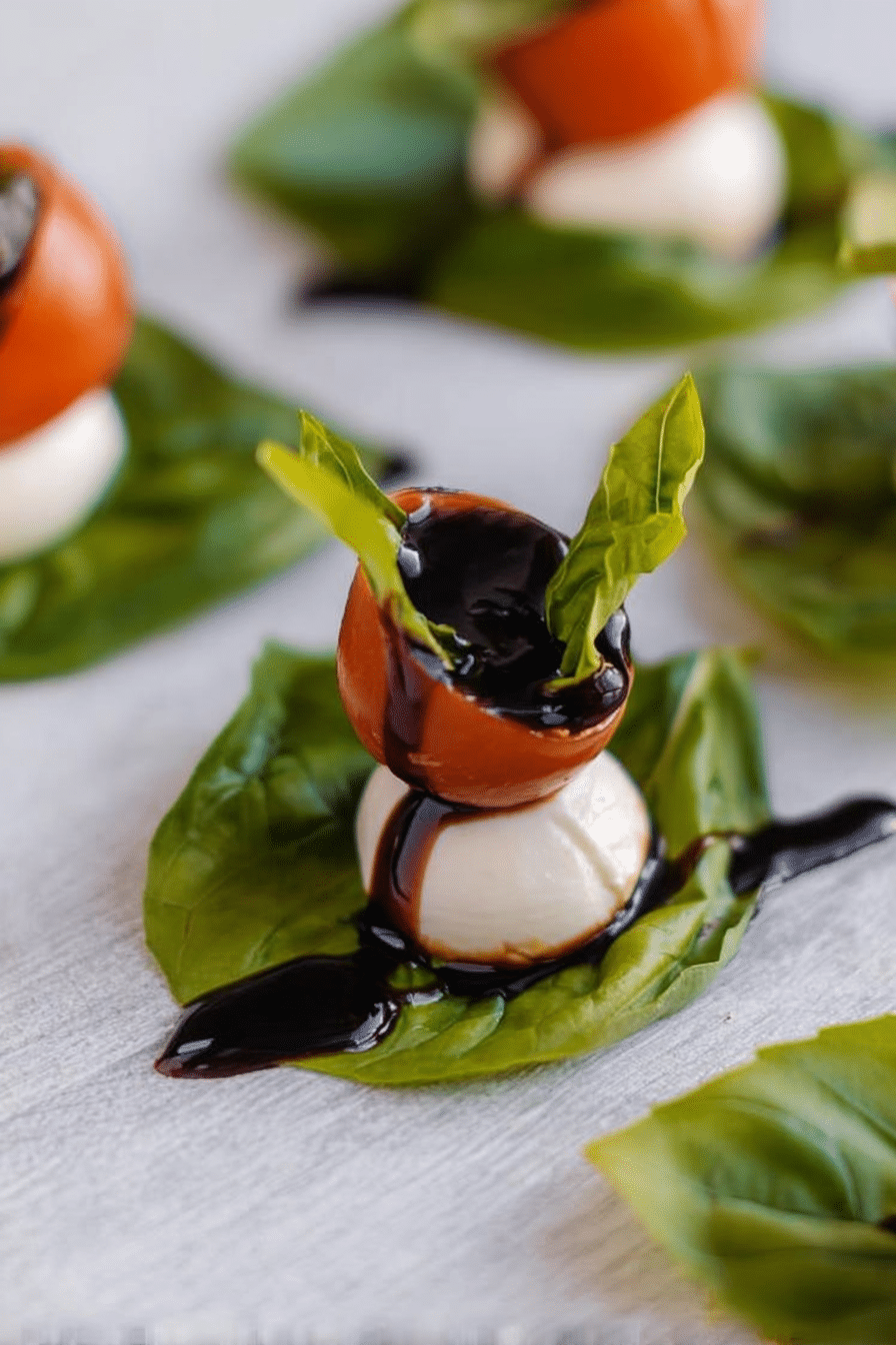 Bite Sized Keto Caprese Appetizer auf einem eleganten Servierteller mit frischem Basilikum.