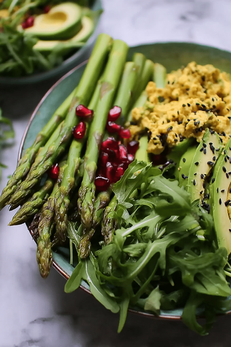 Grüne Spargel-Bowl mit Tofu, Avocado und schwarzen Bohnen, garniert mit Kräutern und Zitrone.
