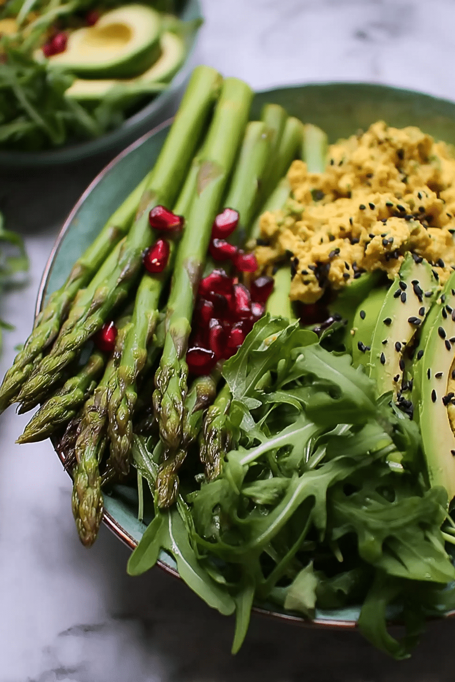Grüne Spargel-Bowl mit Tofu, Avocado und schwarzen Bohnen, garniert mit Kräutern und Zitrone.