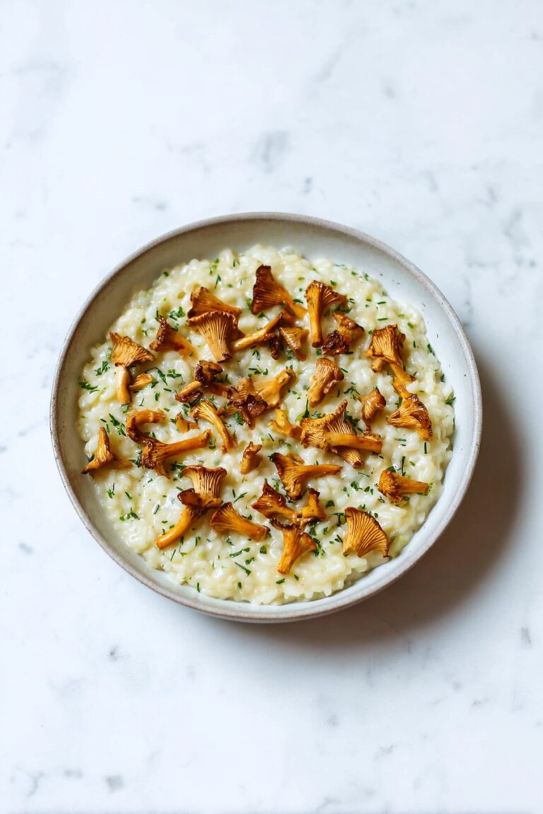 Cremiges Risotto mit Pfifferlingen und Estragon auf einem Holztisch