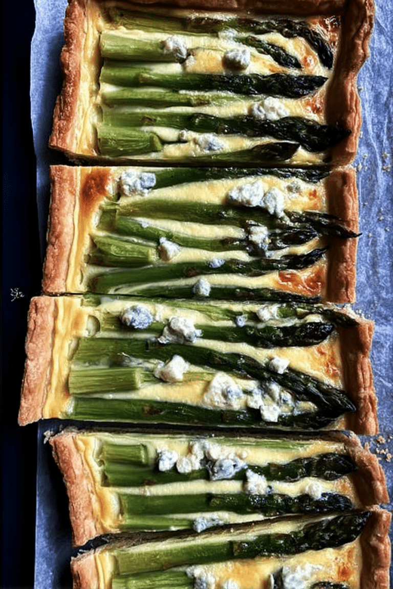 Schnelle Spargel Quiche mit Blätterteig, serviert auf einem Holzbrett, umgeben von frischem Spargel und Gemüse.