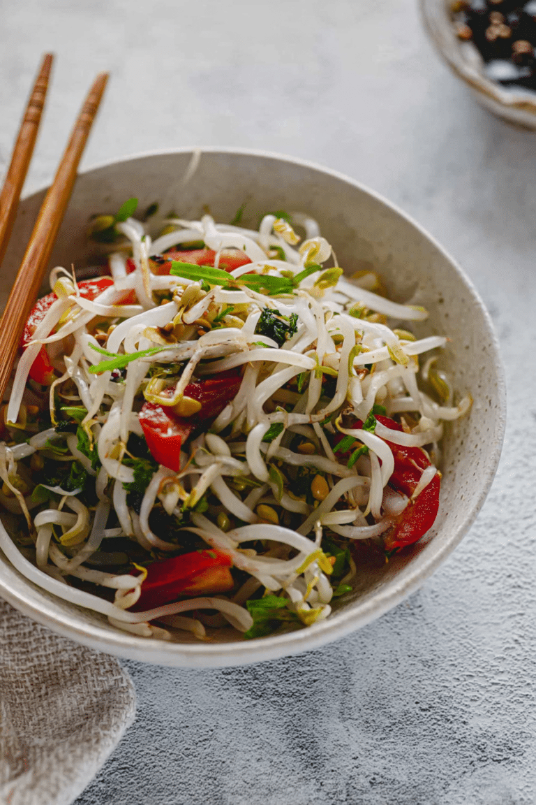 Sojasprossensalat mit Frühlingszwiebeln und Chili an einem asiatischen Hintergrund.