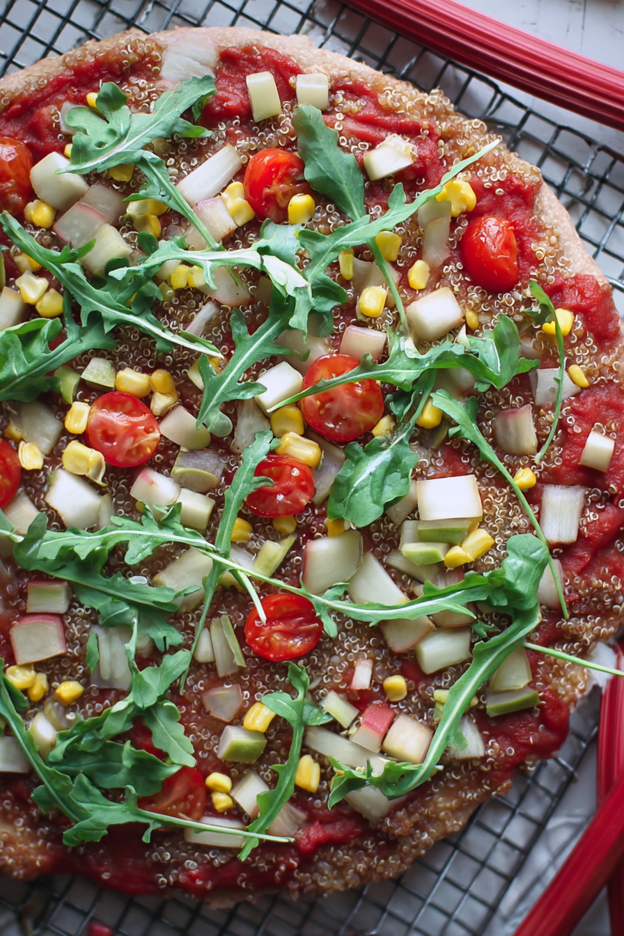 Vegane Quinoa-Pizza mit glutenfreier Kruste und buntem Gemüse auf einem Holzbrett.